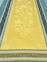 Load image into Gallery viewer, Anti-stain teflon treatment allows for liquids to bead off. Measures 20.5 by 58 in. Pictured on a 72 inch length table for reference, but may be draped over the sides of a smaller table as well. Pictured in ramatuelle absinthe with contrasting yellow at center with dark blue and turquoise at intersecting floral garland borders featuring jacquard woven pomegranate-like baroque floral blooms and beautifully detailed leaves and bouquets of intertwined branching elaborated fleur de lys.