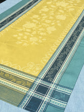 Load image into Gallery viewer, Anti-stain teflon treatment. Measures 20.5 by 58 in. Pictured on a 72 inch length table for reference, but may be draped over the sides of a smaller table as well. Pictured in ramatuelle absinthe with contrasting yellow at center with dark blue and turquoise at intersecting floral garland borders featuring jacquard woven pomegranate-like baroque floral blooms and beautifully detailed leaves and bouquets of intertwined branching elaborated fleur de lys.