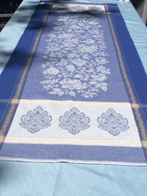 Load image into Gallery viewer, Anti-stain teflon treatment allows for liquids to bead off and universal wipe clean finish allows for liquids and oils to bead off. Measures 20.5 by 58 in. Pictured on a 72 inch length table for reference, but may be draped over the sides of a smaller table as well. Pictured in caprice blue featuring jacquard woven pomegranate-like baroque floral blooms and beautifully detailed leaves and bouquets of intertwined branching elaborated fleur de lys.
