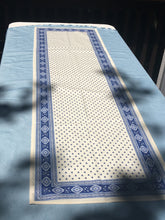 Load image into Gallery viewer, Acrylic coating allows for universal wipe clean finish, allowing for liquids and oils to bead off. Measures 16.5 by 60 in. Pictured on a 72 inch length table for reference, but may be draped over the sides of a smaller table as well. Manufactured by l&#39;Ensoillade and made in France. Pictured in safran yellow with deep red accents.
