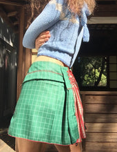 Load image into Gallery viewer, dirndle back multi navy satin bow ruched plaid taffeta upcycled chruistmas napkin waist cuffed pleat flounce school uniform skirt great for holiday winter parties or camp cosplay fashion. Upcycled Christmas nakins are a grid of dark evergreen with bright red woven edges.