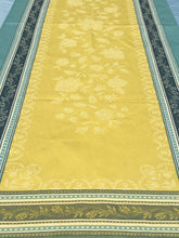 Load image into Gallery viewer, Anti-stain teflon treatment allows for liquids to bead off. Measures 20.5 by 58 in. Pictured on a 72 inch length table for reference, but may be draped over the sides of a smaller table as well. Pictured in ramatuelle absinthe with contrasting yellow at center with dark blue and turquoise at intersecting floral garland borders featuring jacquard woven pomegranate-like baroque floral blooms and beautifully detailed leaves and bouquets of intertwined branching elaborated fleur de lys.
