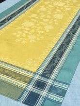 Load image into Gallery viewer, Anti-stain teflon treatment. Measures 20.5 by 58 in. Pictured on a 72 inch length table for reference, but may be draped over the sides of a smaller table as well. Pictured in ramatuelle absinthe with contrasting yellow at center with dark blue and turquoise at intersecting floral garland borders featuring jacquard woven pomegranate-like baroque floral blooms and beautifully detailed leaves and bouquets of intertwined branching elaborated fleur de lys.
